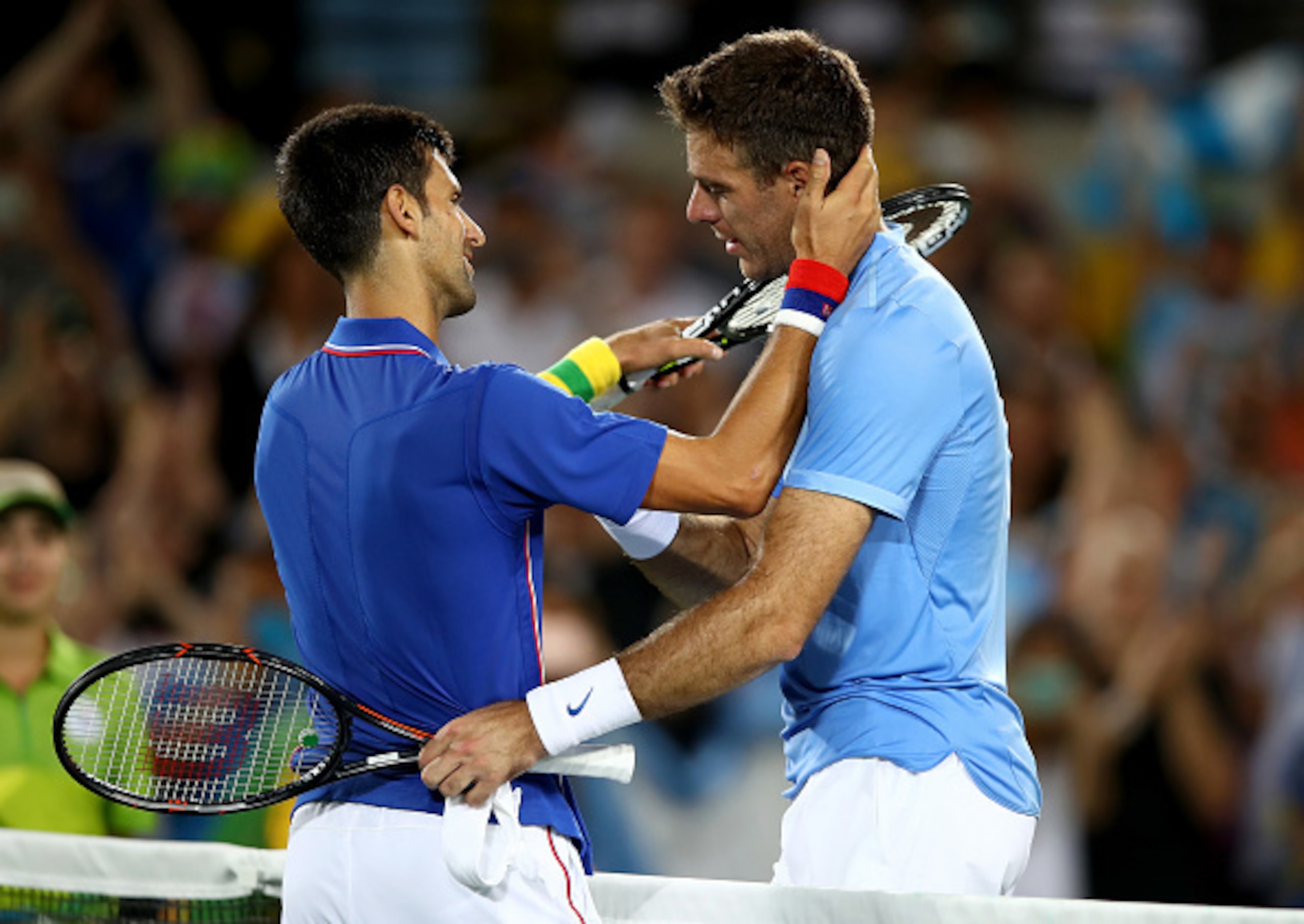 Novak Djokovic congratulates Juan Martin del Potro after losing to him in the first round of the men's singles competition.