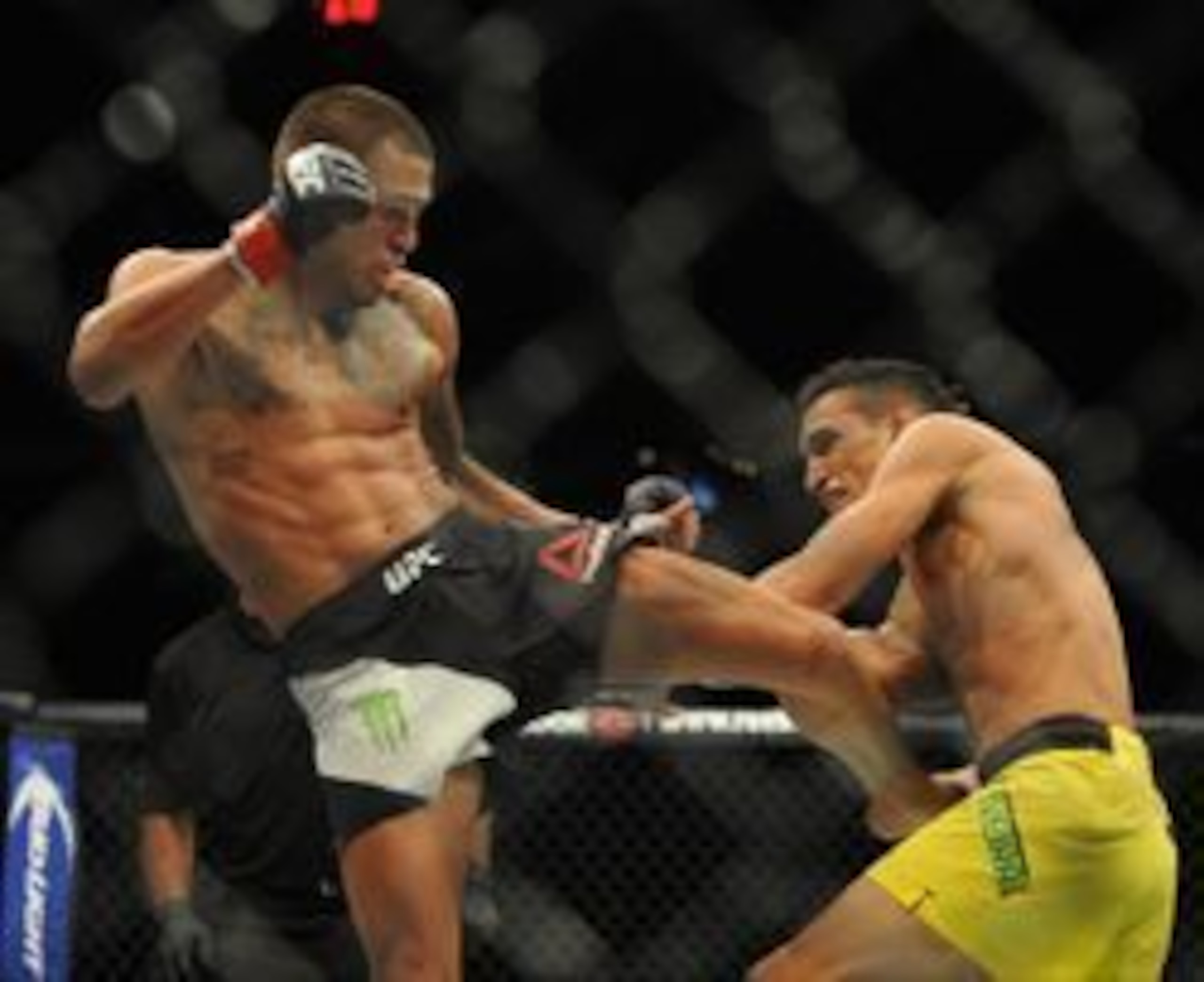 Anthony Pettis (left) kicks Charles Oliveira.
