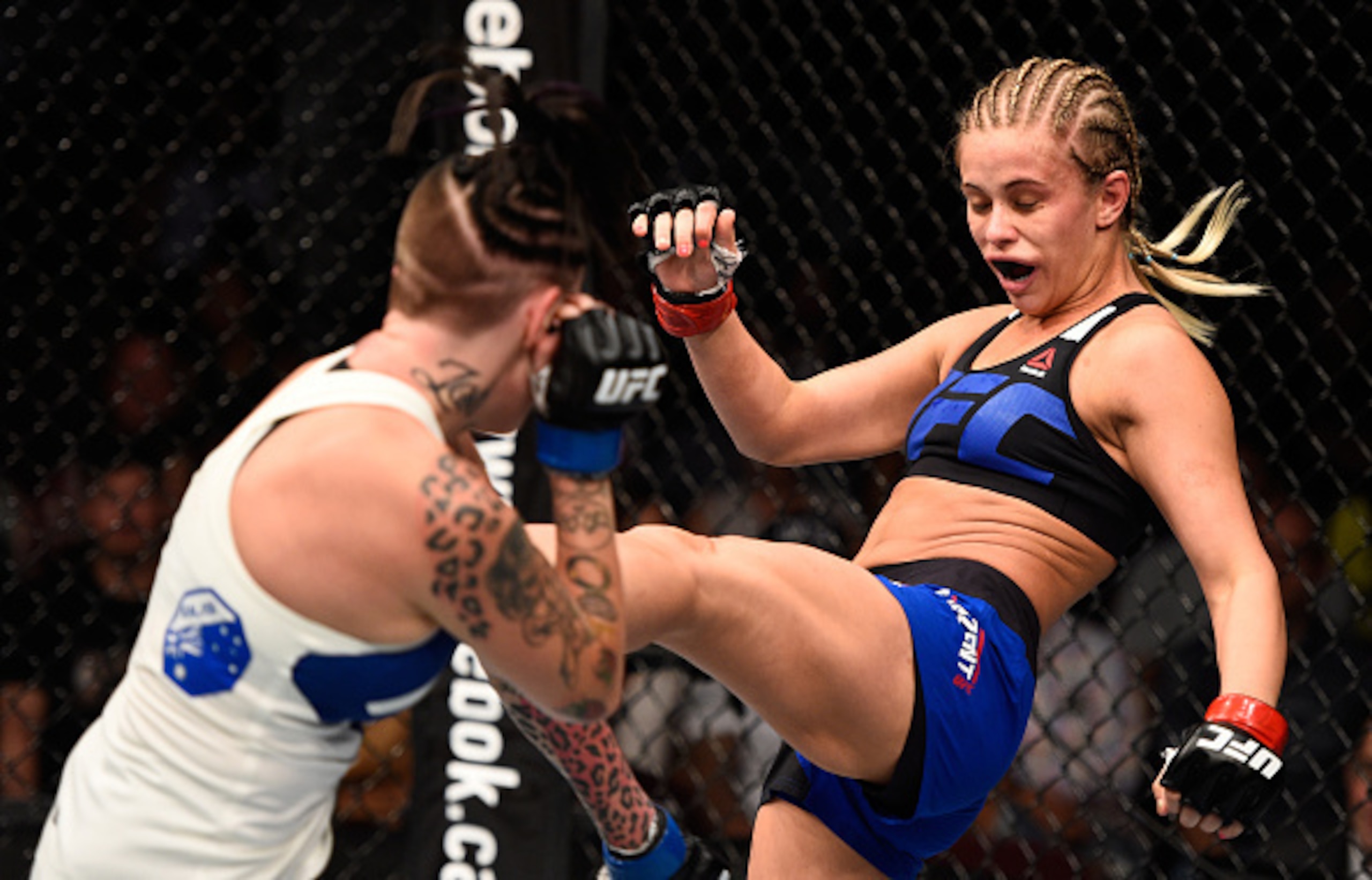 Paige VanZant (right) lands a kick on Bec Rawlings.