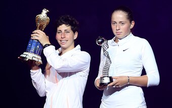 Carla Suarez Navarro of Spain and Jelena Ostapenko of Latvia (R) pose with their trophies at the end of their Qatar Open final tennis match on February 27, 2016 in the Qatari capital Doha.  
Spain's Carla Suarez Navarro came from a set behind against Latv