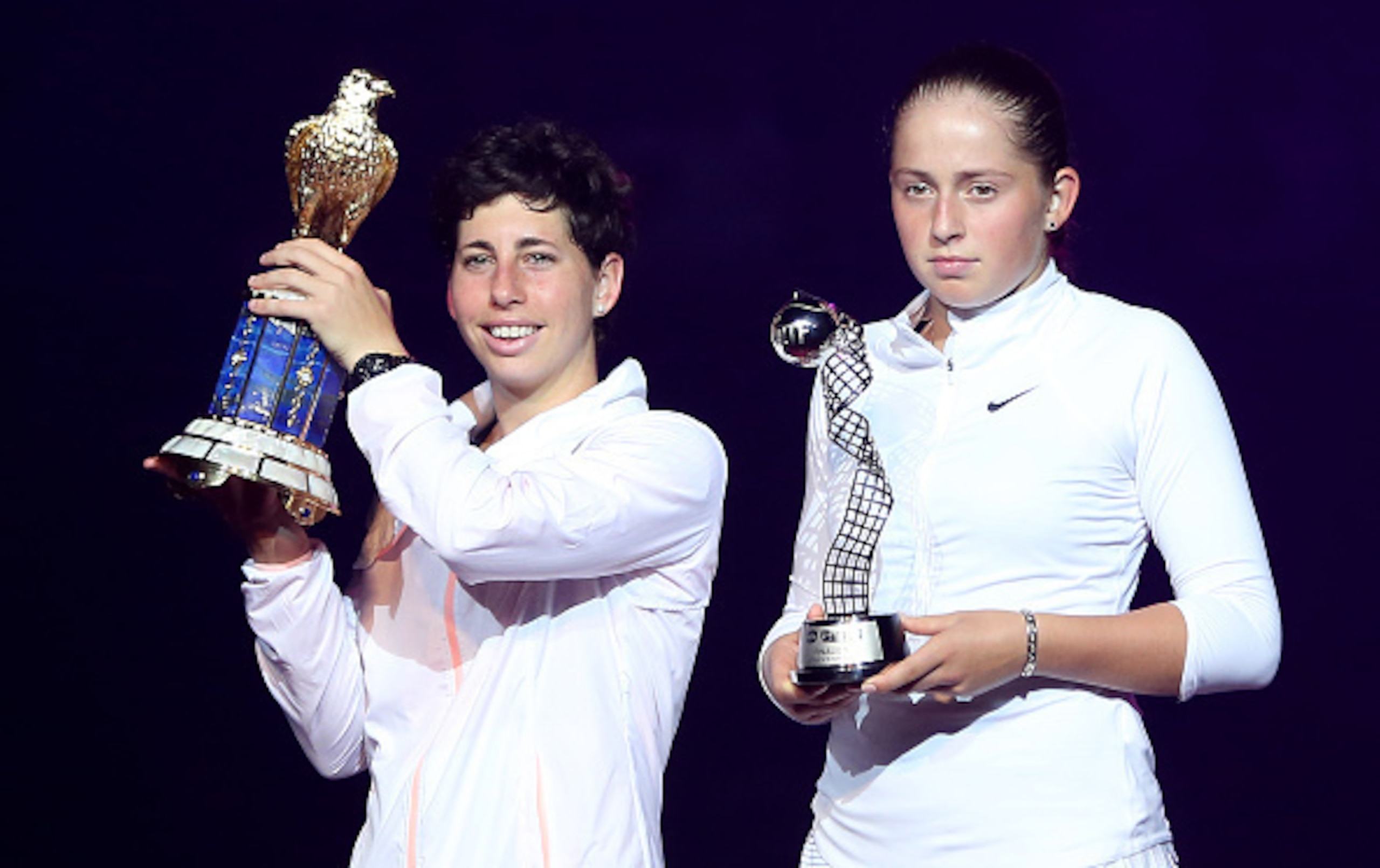Carla Suarez Navarro of Spain and Jelena Ostapenko of Latvia (R) pose with their trophies at the end of their Qatar Open final tennis match on February 27, 2016 in the Qatari capital Doha.  
Spain's Carla Suarez Navarro came from a set behind against Latv