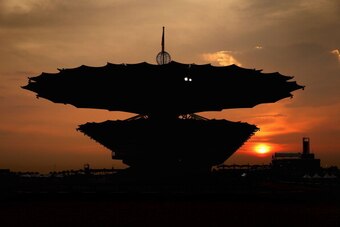 The sun sets behind the main grandstand at Sepang.