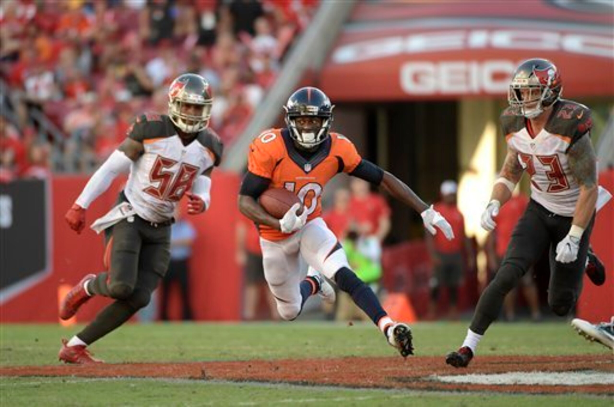 Denver Broncos wide receiver Emmanuel Sanders (10) runs after catching a pass between Tampa Bay Buccaneers middle linebacker Kwon Alexander (58) and strong safety Chris Conte (23) during the second half of an NFL football game in Tampa, Fla., Sunday, Oct.