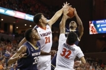 Power forward Isaiah Wilkins (21) and point guard London Perrantes (32) rising up to block a shot.