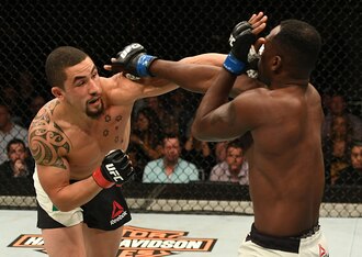 Robert Whittaker punches Derek Brunson.