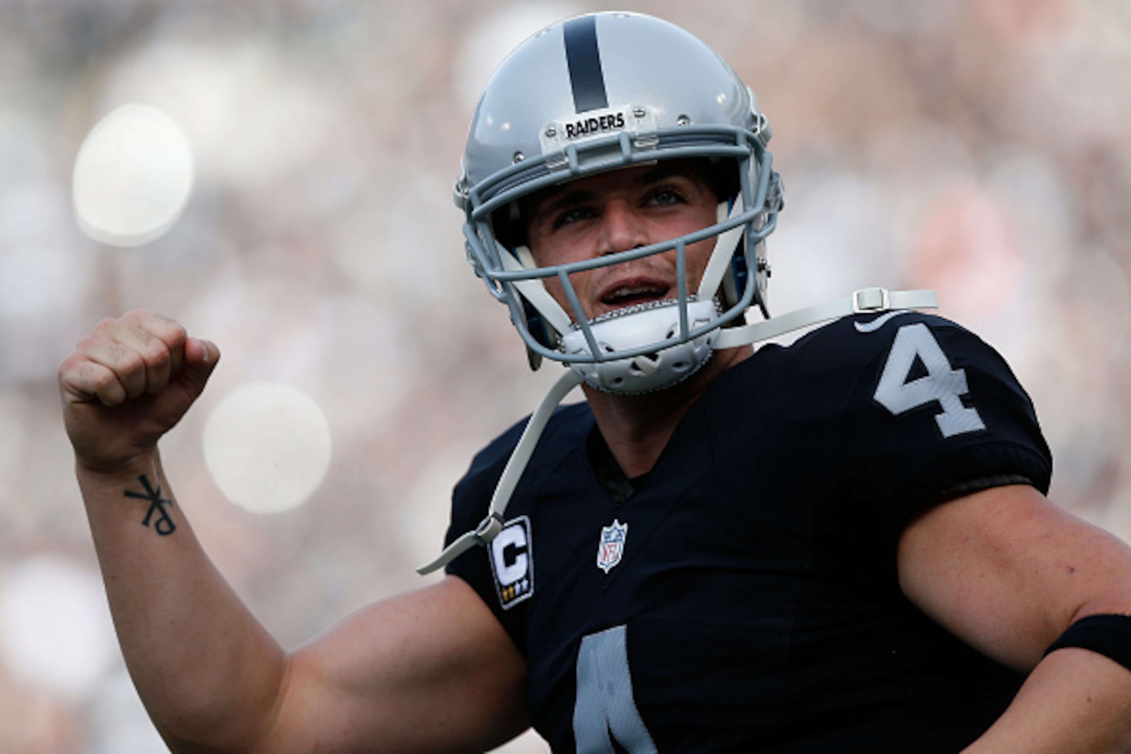 OAKLAND, CA - NOVEMBER 27:  Derek Carr #4 of the Oakland Raiders celebrates after a touchdown by Latavius Murray #28 against the Carolina Panthers during their NFL game on November 27, 2016 in Oakland, California.  (Photo by Lachlan Cunningham/Getty Image
