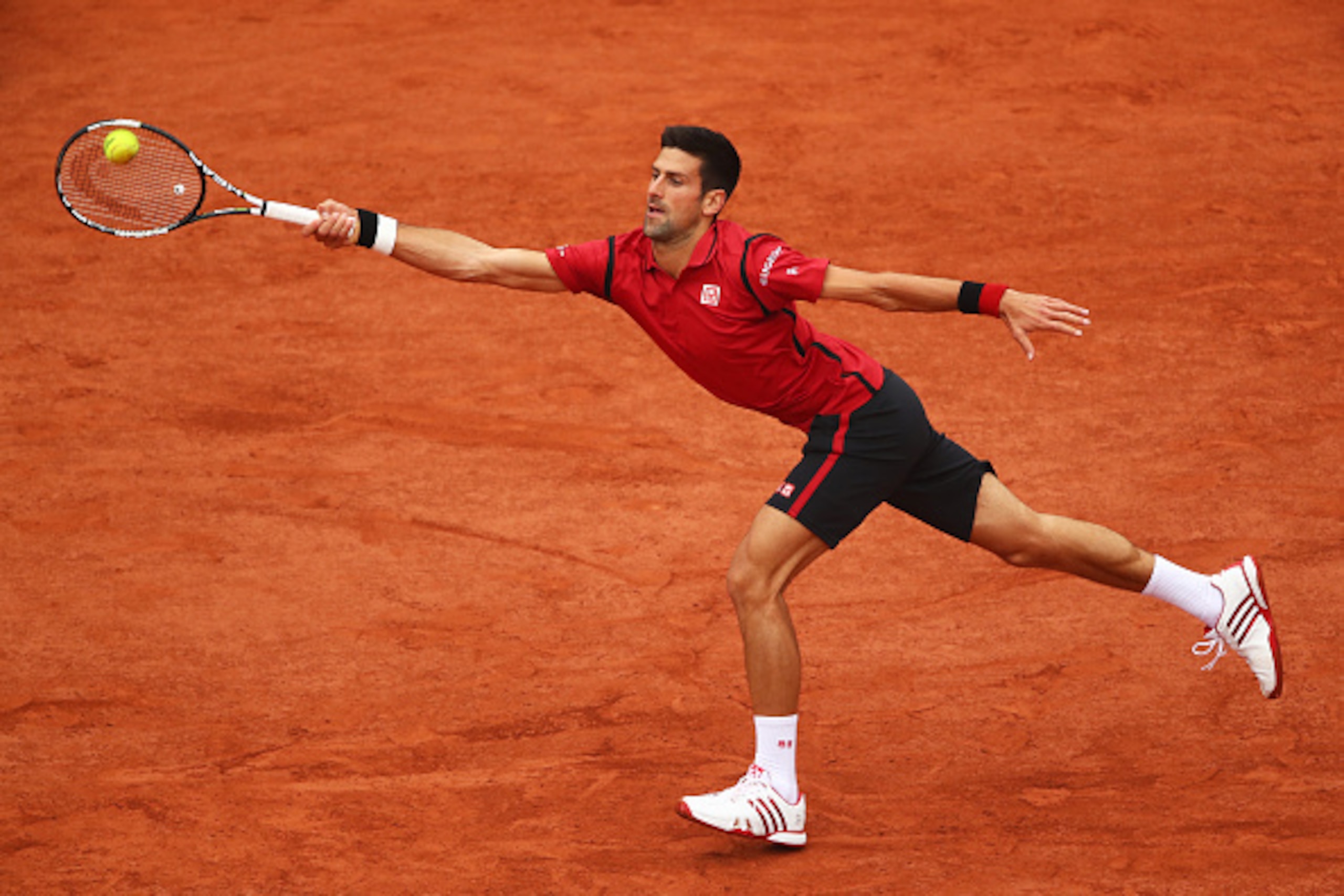 Novak Djokovic reaches to make a play on the ball during the 2016 French Open.