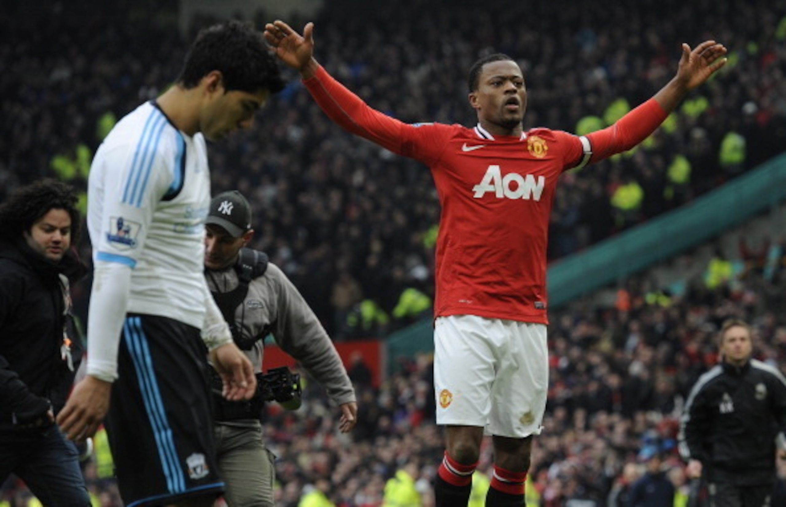 Patrice Evra coincidentally celebrates a United win quite near Luis Suarez.