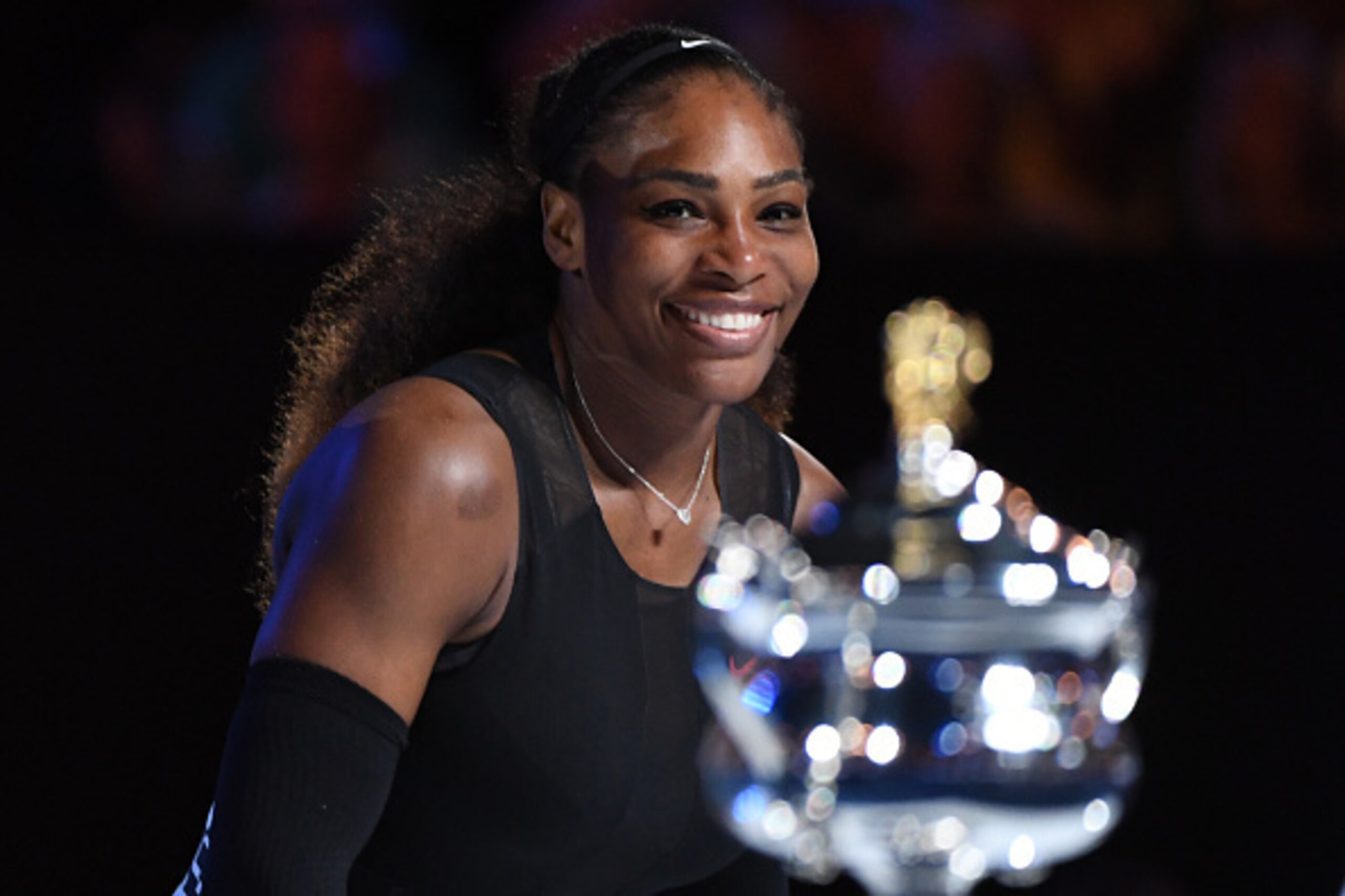 A beaming Williams eyes her championship trophy.