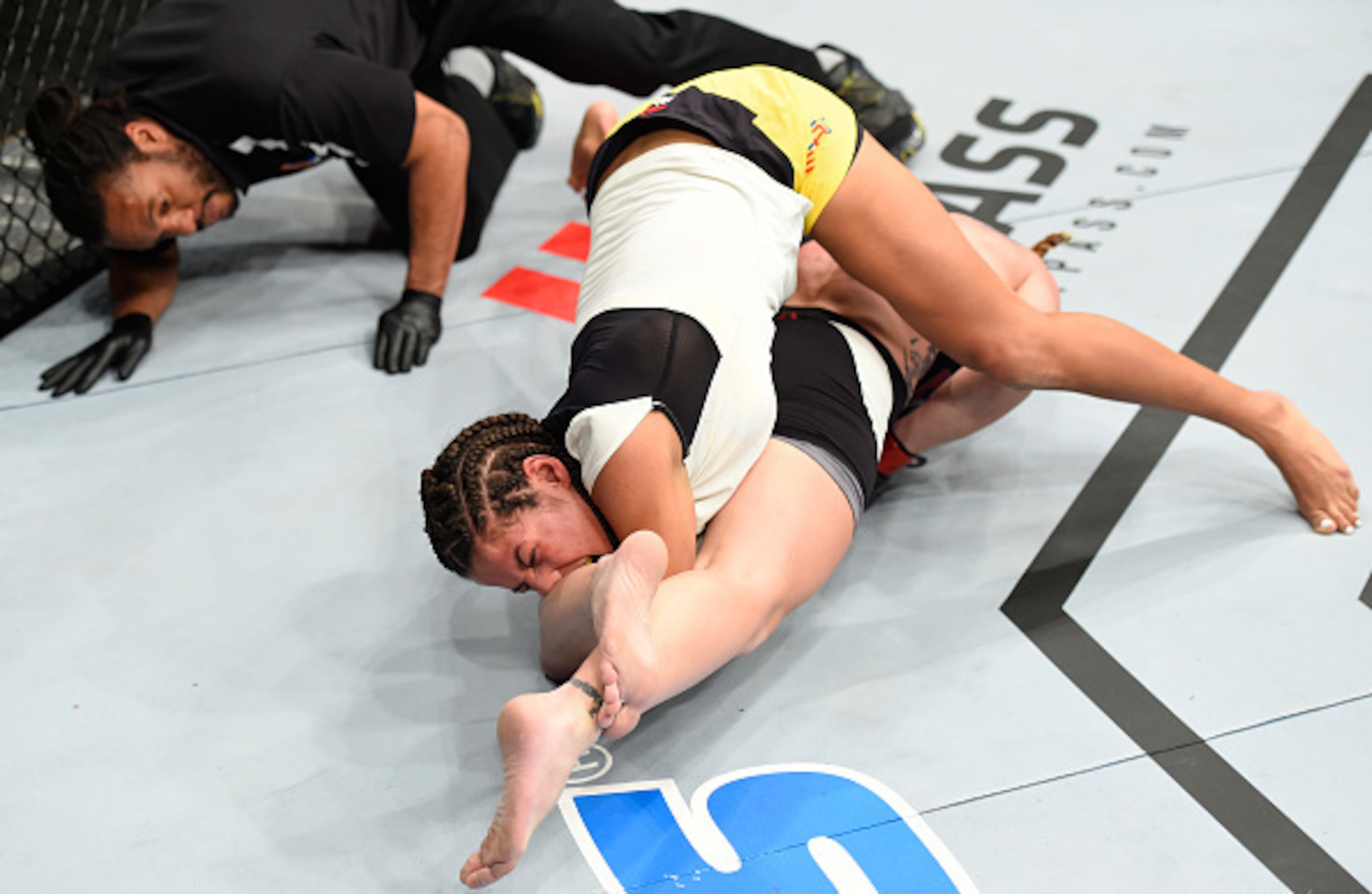 Julianna Pena grimaces as Valentina Shevchenko locks on the armbar.