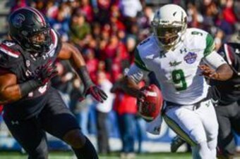 Dec 29, 2016; Birmingham, AL, USA; South Florida Bulls quarterback Quinton Flowers (9) runs the ball around South Carolina Gamecocks defensive lineman Stephon Taylor (98) during the first quarter in the 2016 Birmingham Bowl at Legion Field. Mandatory Cred