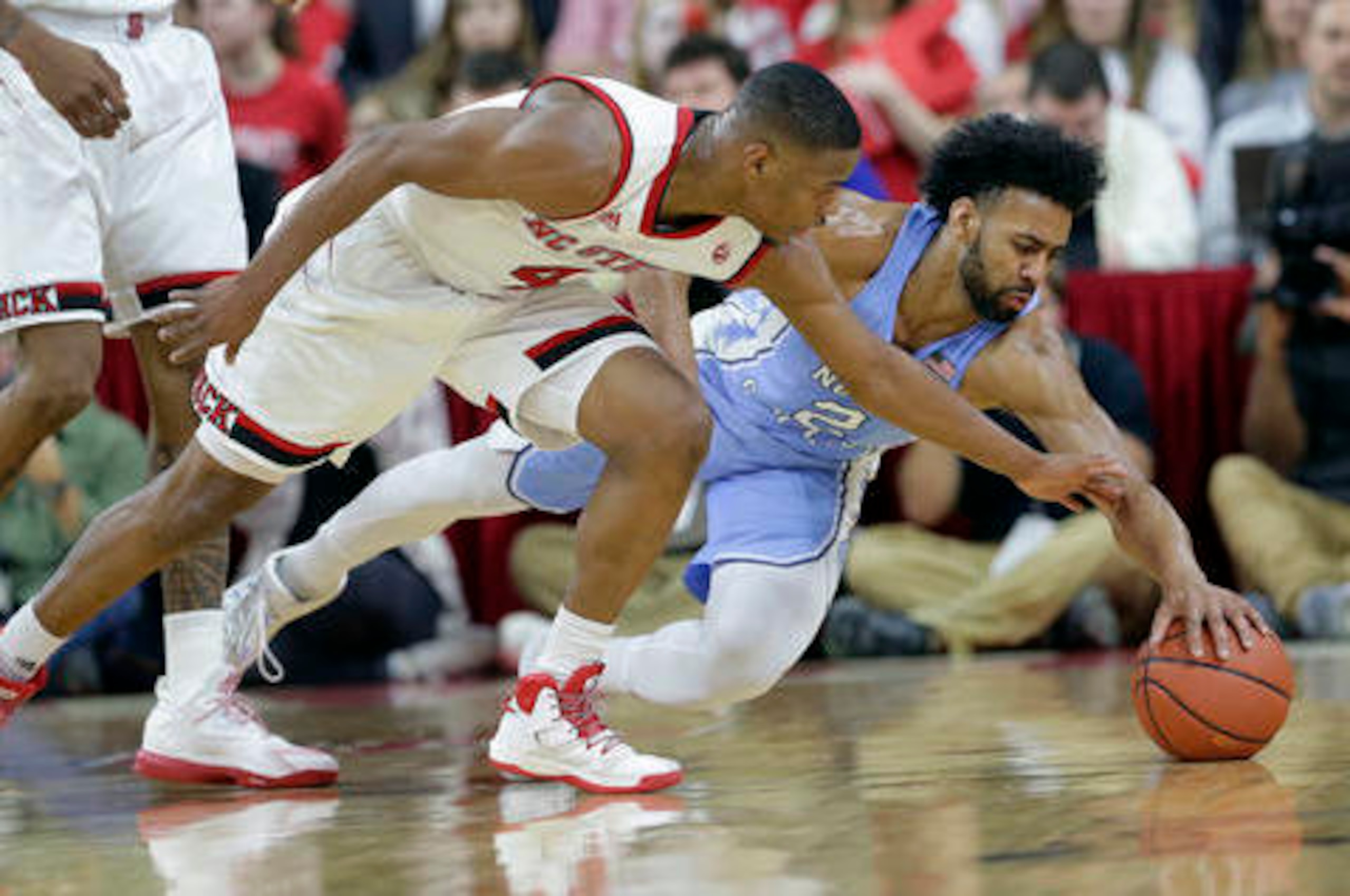 North Carolina's Joel Berry (right) dives for a loose ball with N.C. State's Dennis Smith.