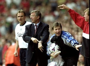 Sir Alex Ferguson pointing to his watch.