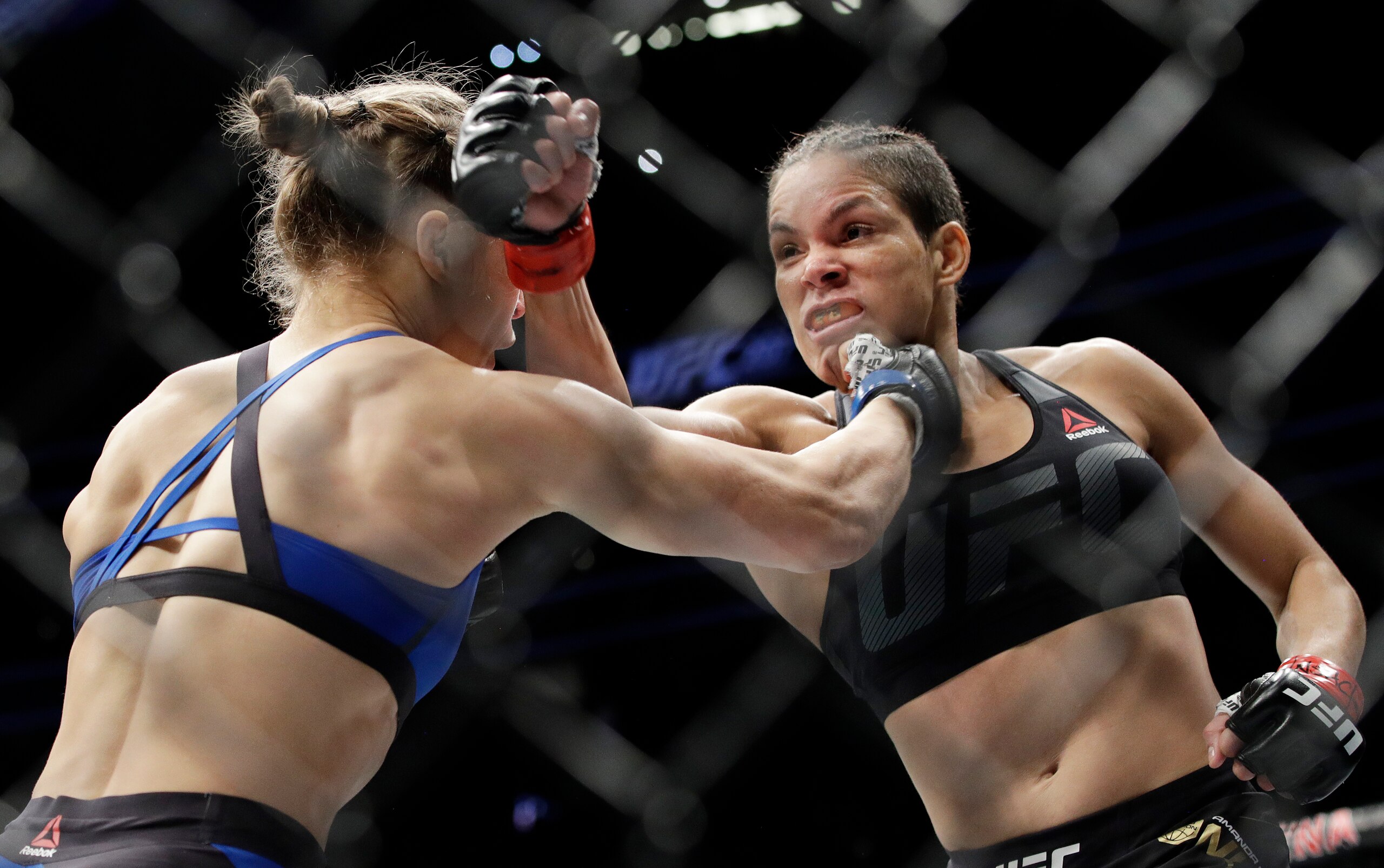 Amanda Nunes (right) punches Ronda Rousey.