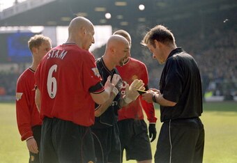 Jaap Stam acts as peacemaker between the referee and Fabien Barthez.