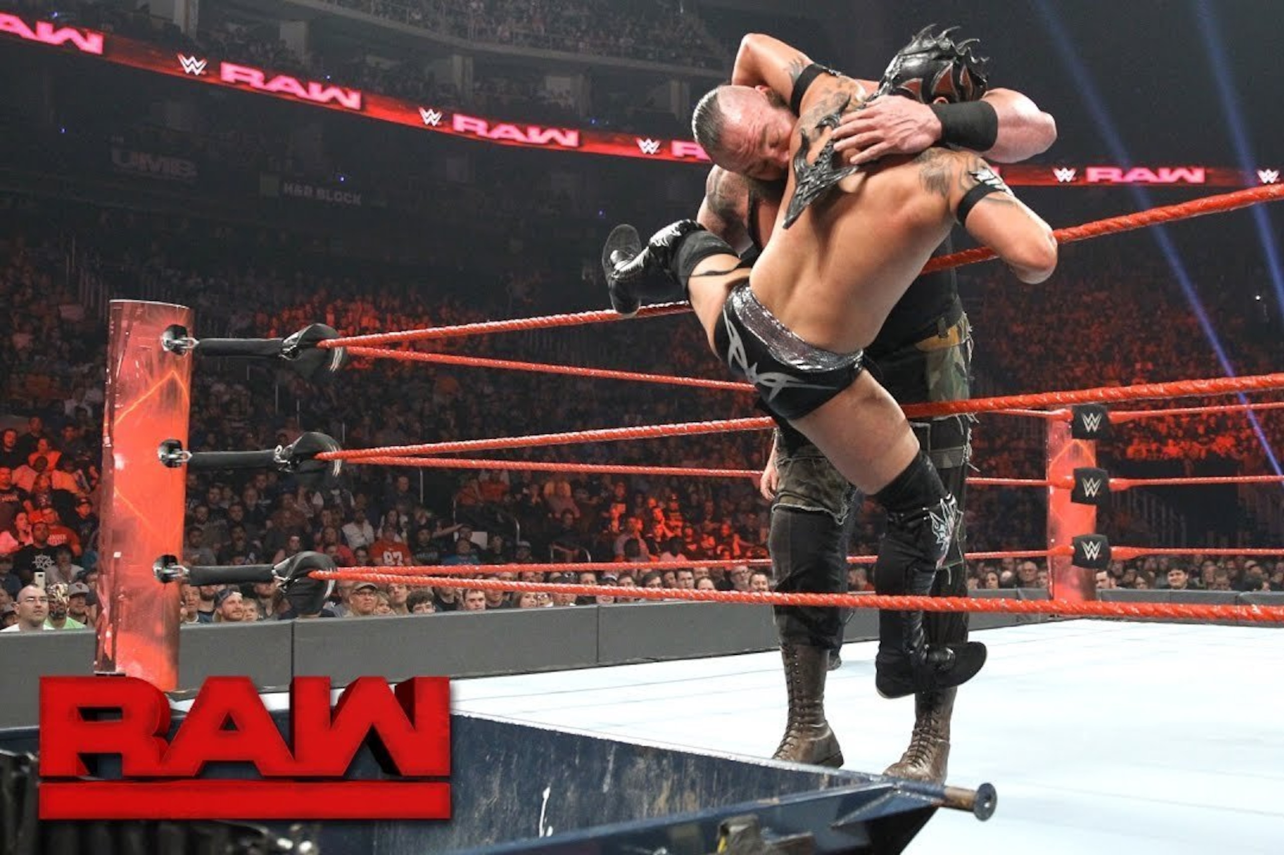 Kalisto attempting to pull Braun Strowman over the top rope into a dumpster.