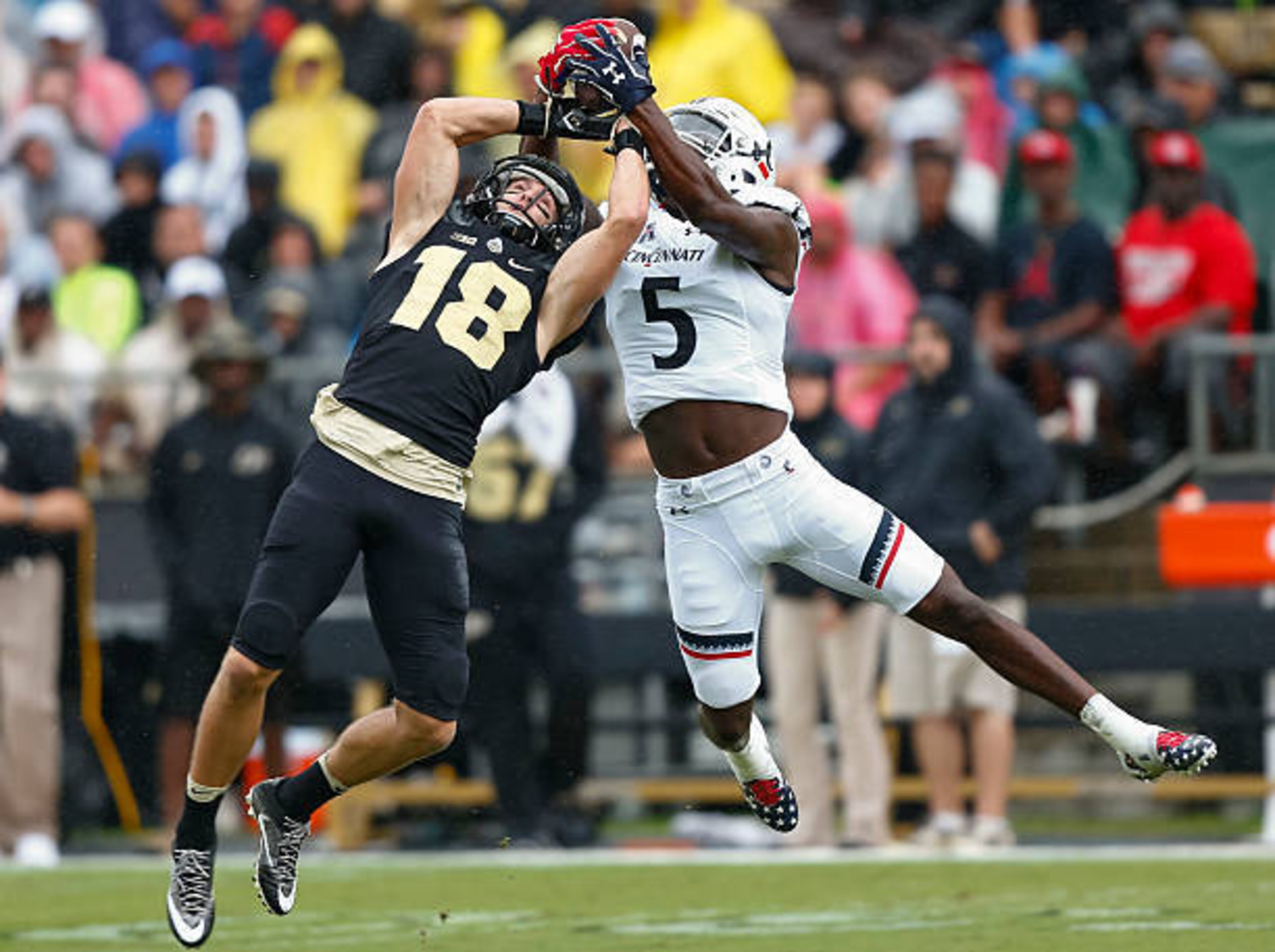 Michael Tyson of the University of Cincinnati (No. 5) reaches up to make a play on a contested catch. Michael Tyson of the University of Cincinnati (No. 5) reaches up to make a play on a contested catch.