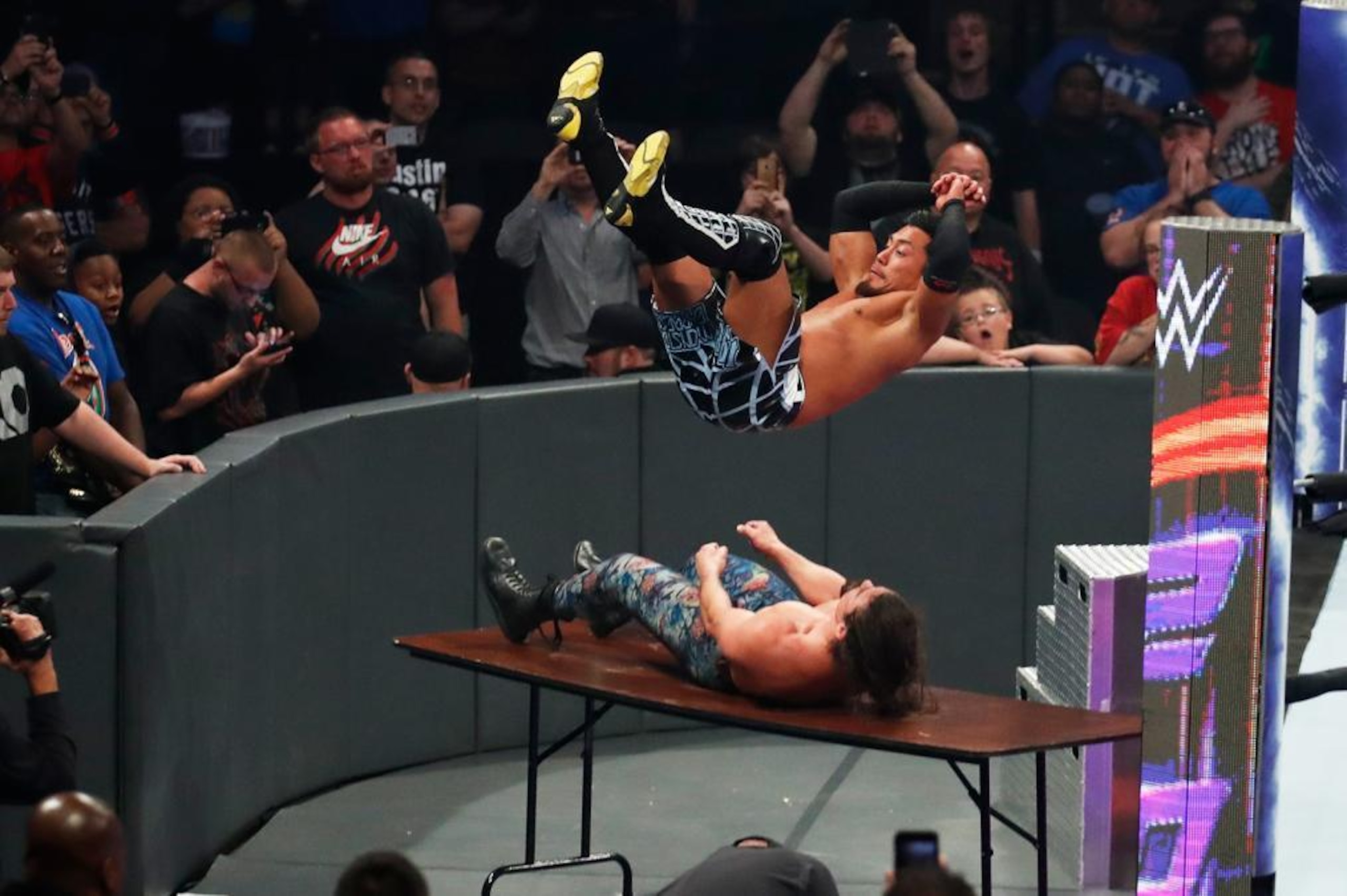 Akira Tozawa putting The Brian Kendrick through a table.