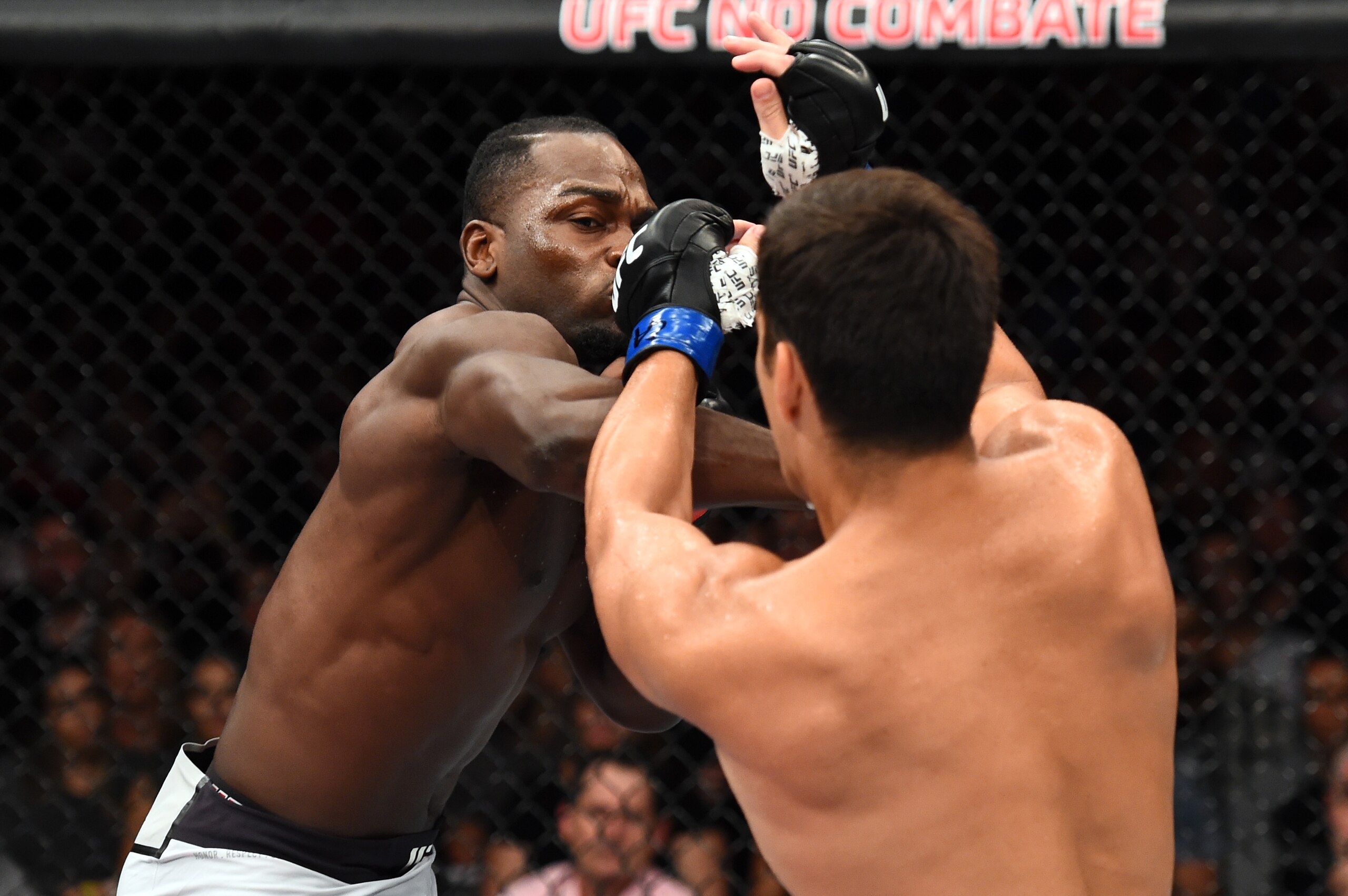 Derek Brunson (left) hits Lyoto Machida (right).