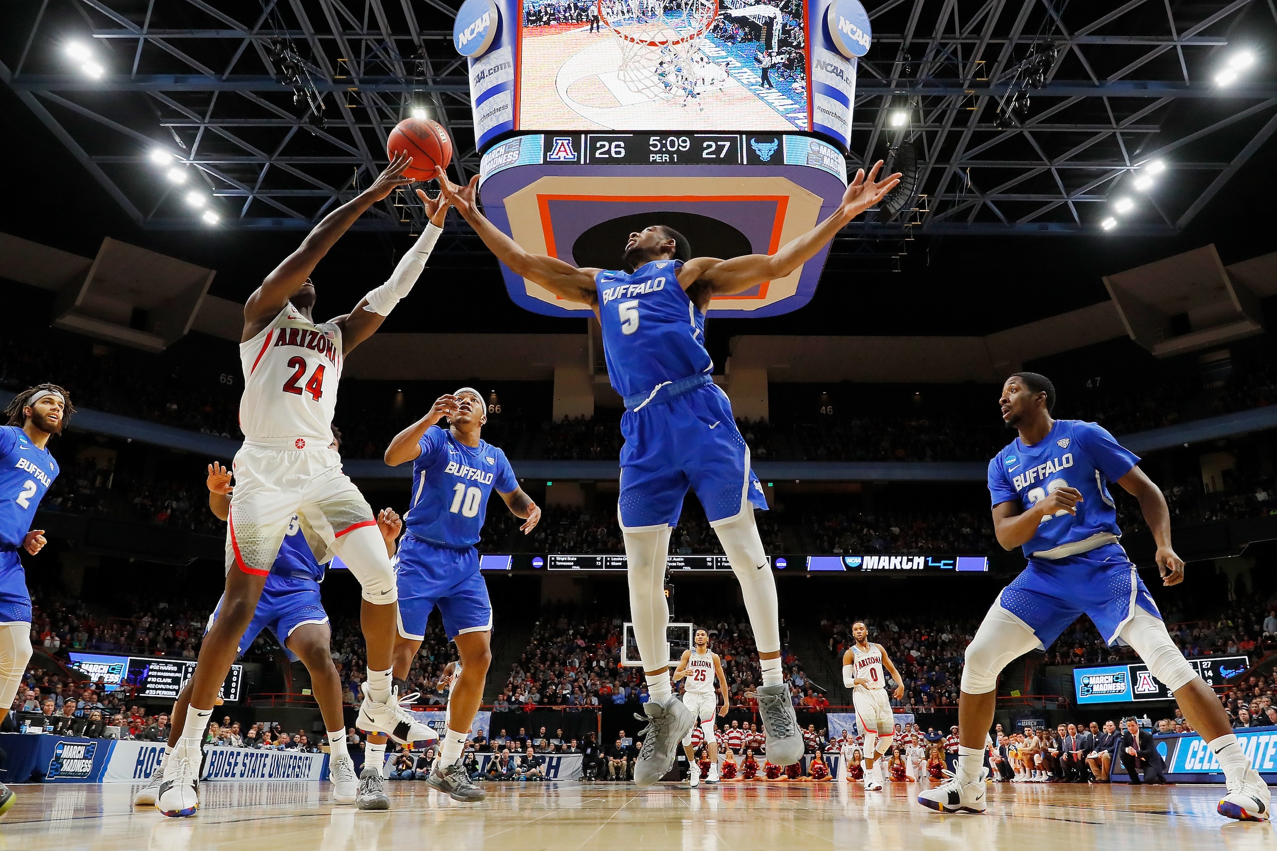 CJ Massinburg (center) tangles with Arizona's Emmanuel Akot.