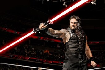 Roman Reigns holding Darth Maul's lightsaber.