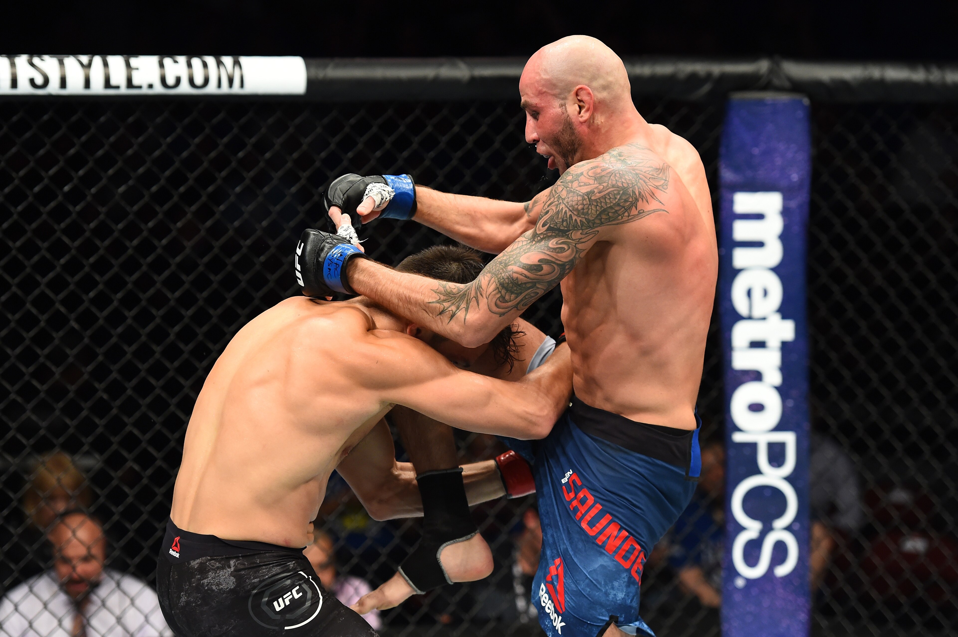 Ben Saunders (right) lands a knee on Jake Ellenberger.
