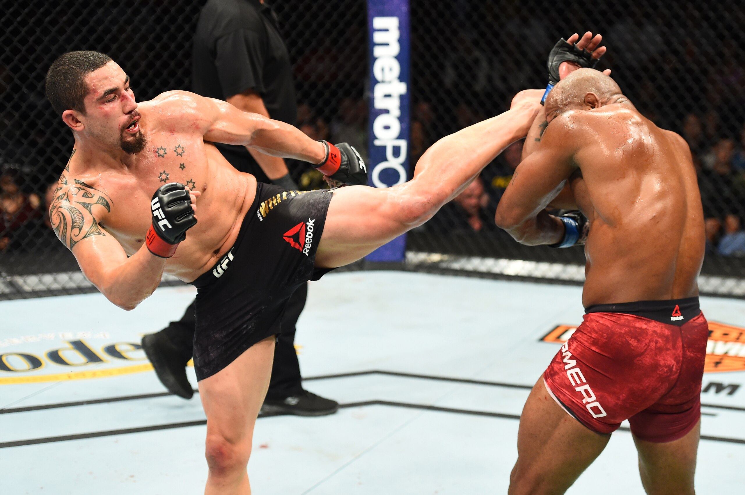 Robert Whittaker (left) kicks Yoel Romero