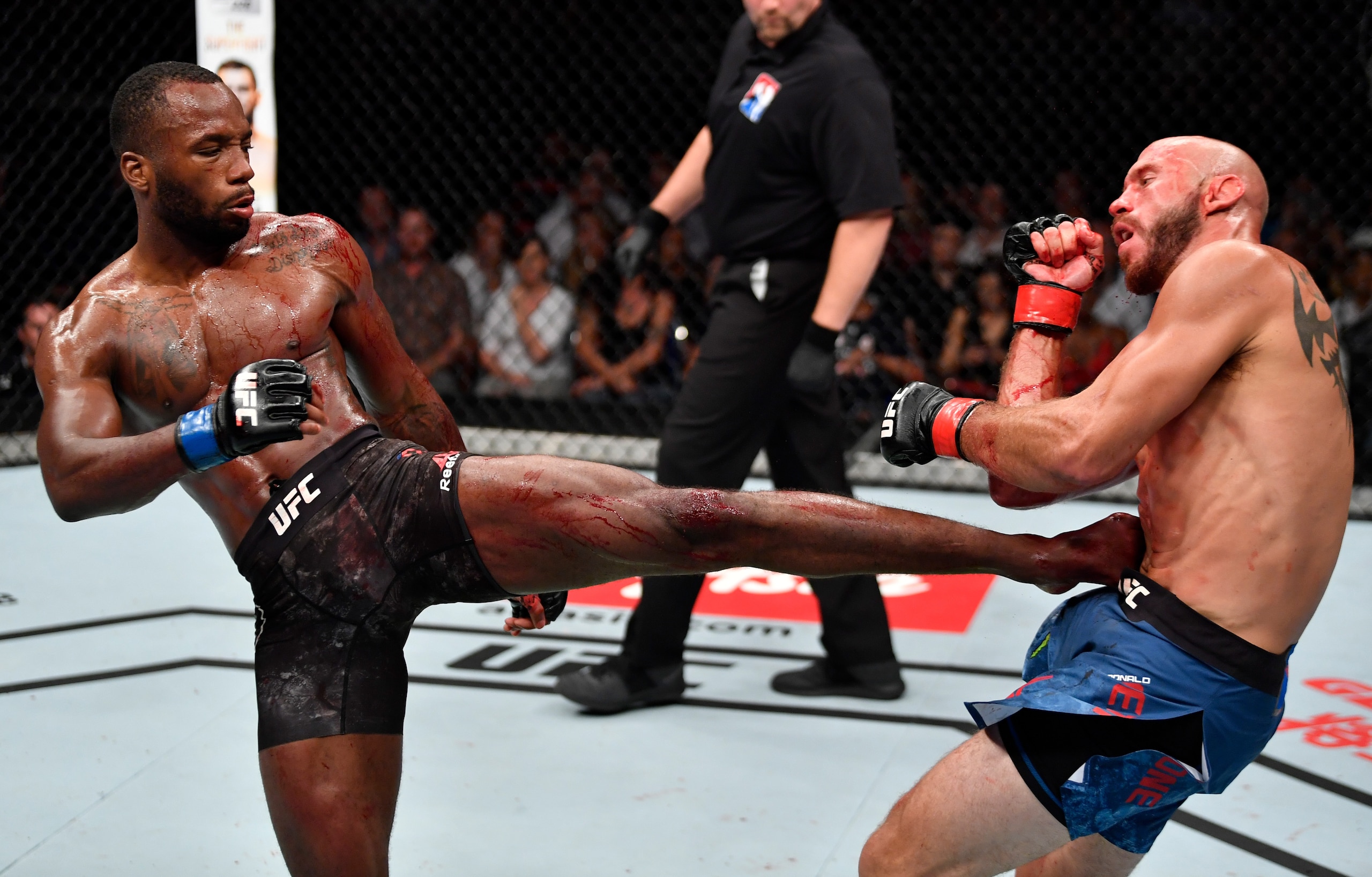 Leon Edwards (left) kicks Donald Cerrone