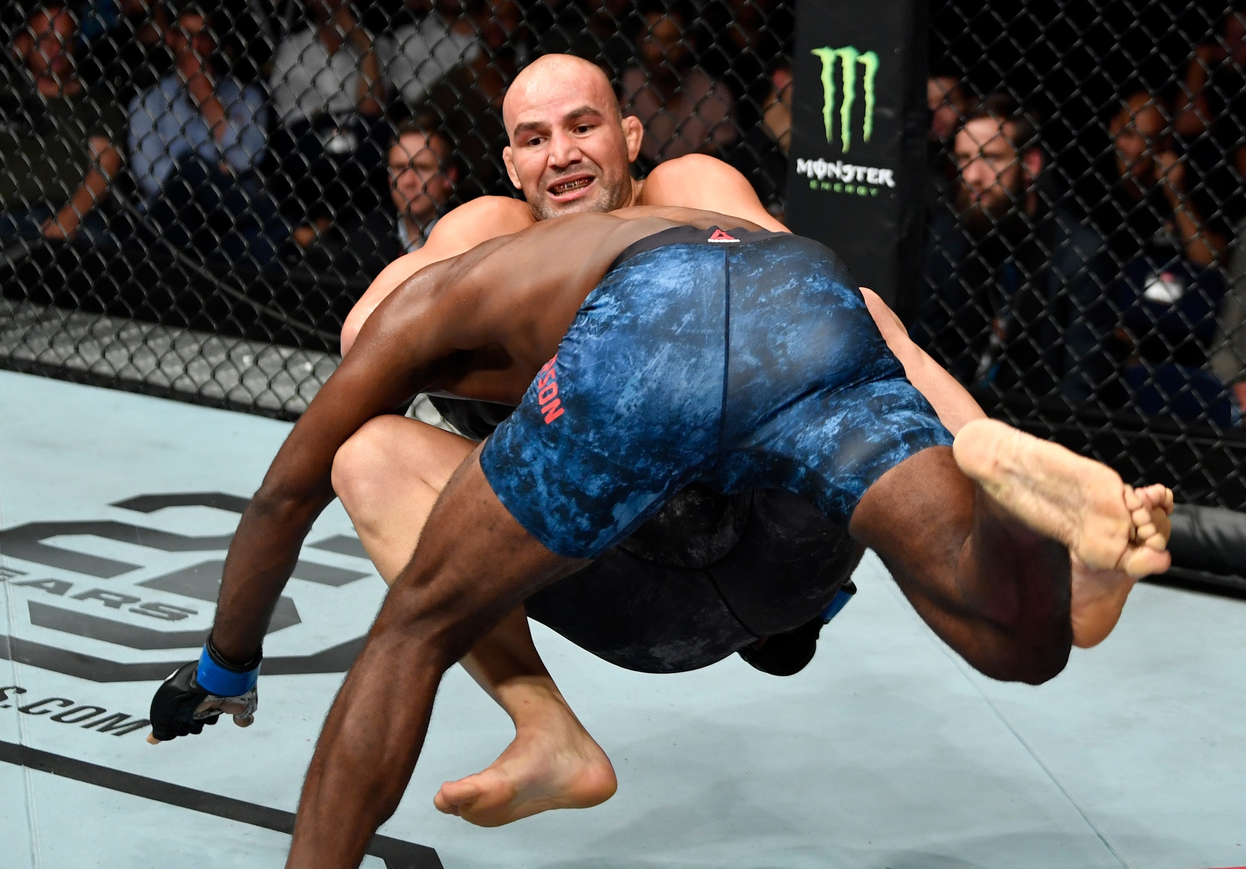 Anderson (blue shorts) takes down Glover Teixeira.