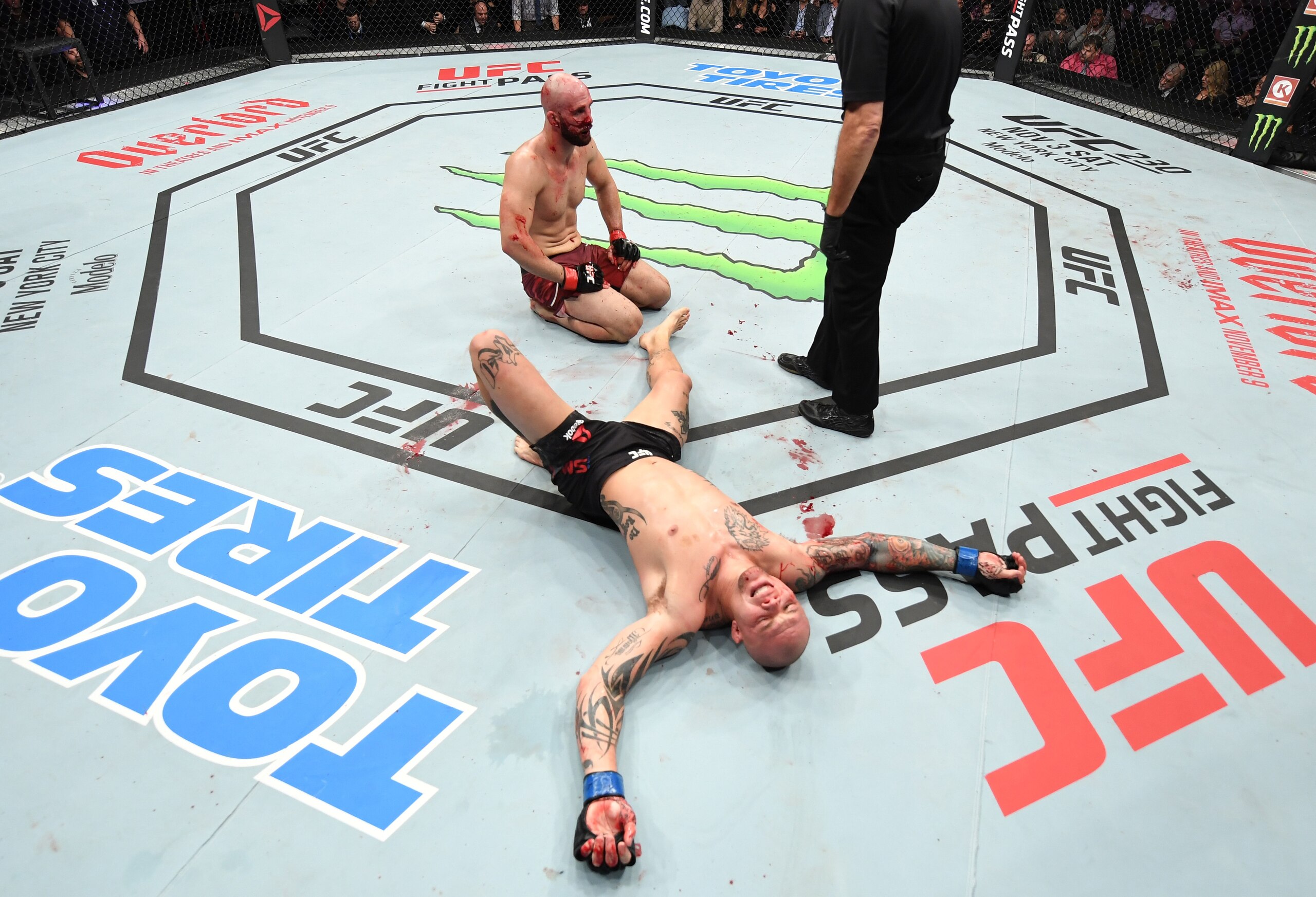 An exhausted Anthony Smith (below) after defeating Volkan Oezdemir (sitting).