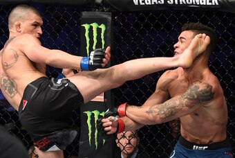 Don Madge (left) lands the head kick on Te Edwards.