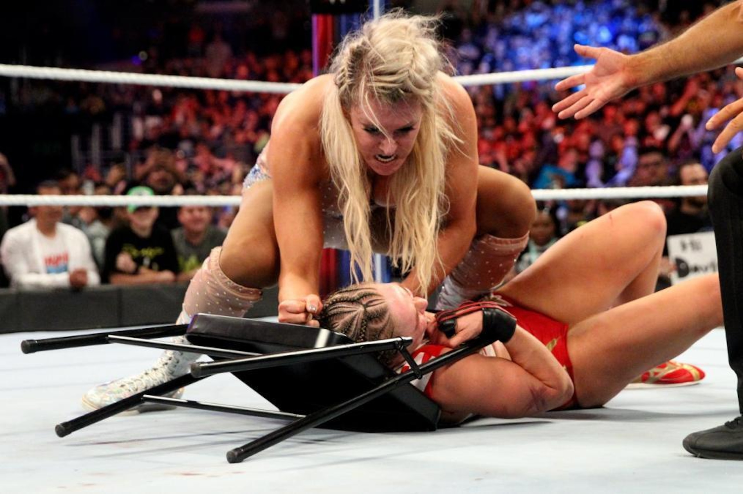 Charlotte Flair using a chair against Ronda Rousey.