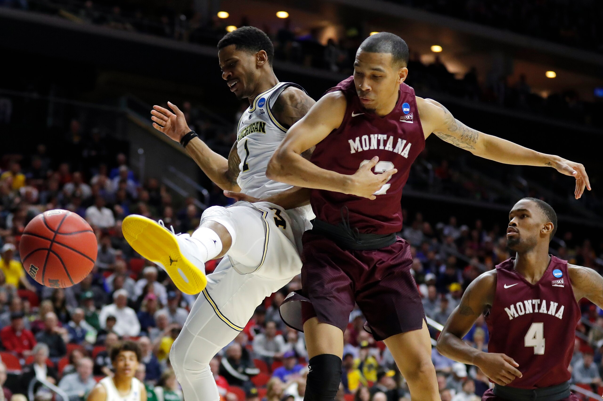 Michigan guard Charles Matthews, left, fights for a loose ball with Montana's Kendal Manuel and Sayeed Pridgett (4) during a first round men's college basketball game in the NCAA Tournament, Thursday, March 21, 2019, in Des Moines, Iowa. (AP Photo/Charlie