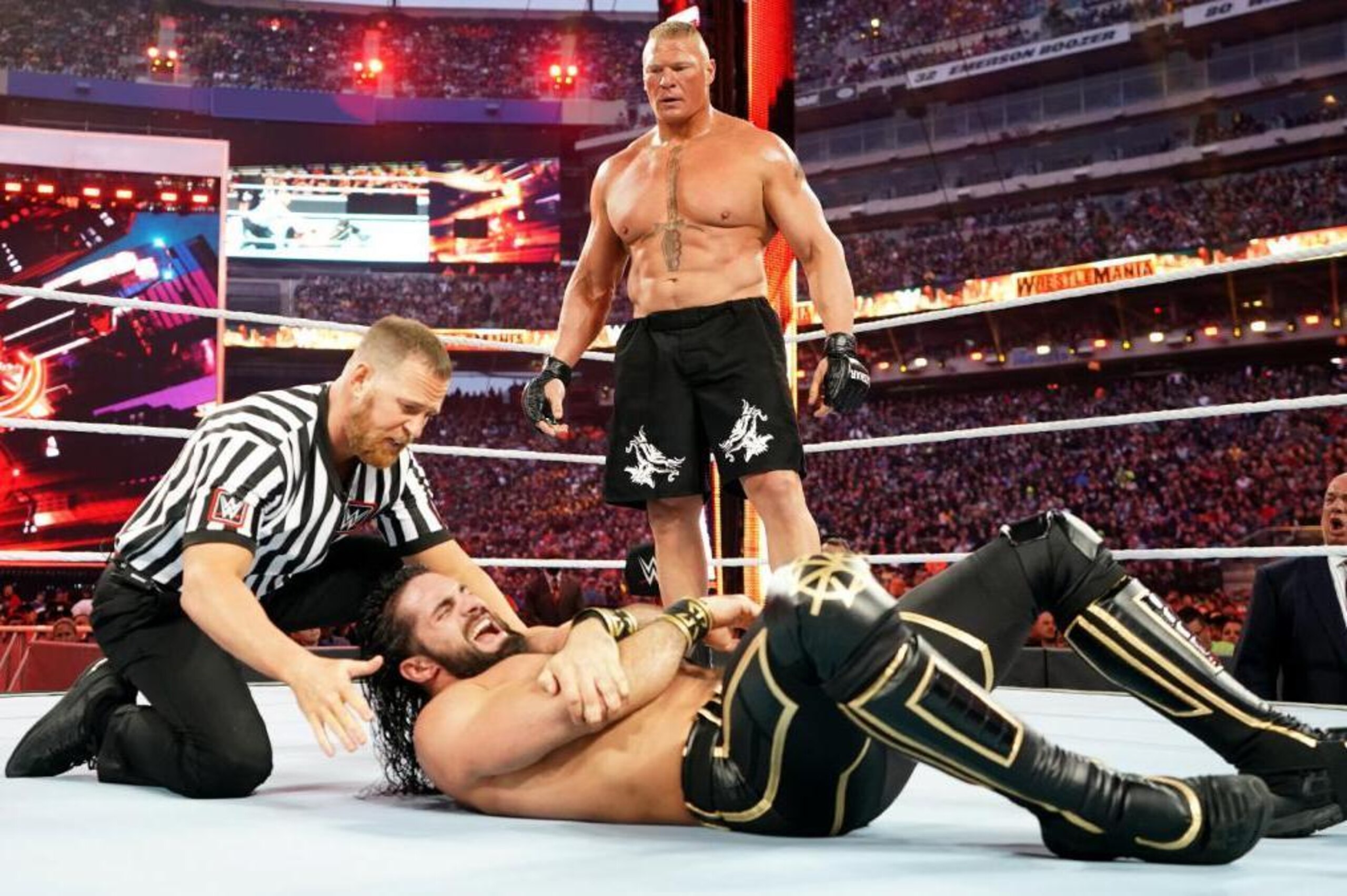 Brock Lesnar standing over Seth Rollins.
