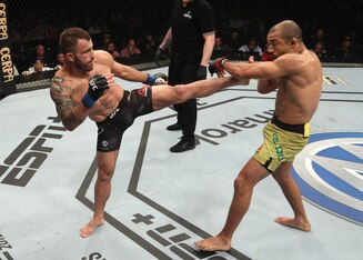 Alexander Volkanovski (left) kicks Jose Aldo.