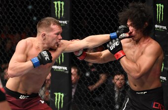 Petr Yan (left) hits John Dodson