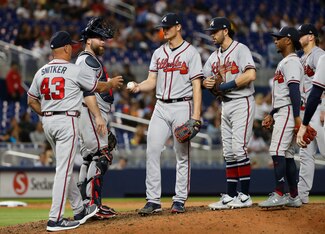 Brian Snitker (L) and Mike Soroka (C)