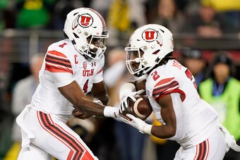 Utah's Tyler Huntley (1) and Zack Moss (2)
