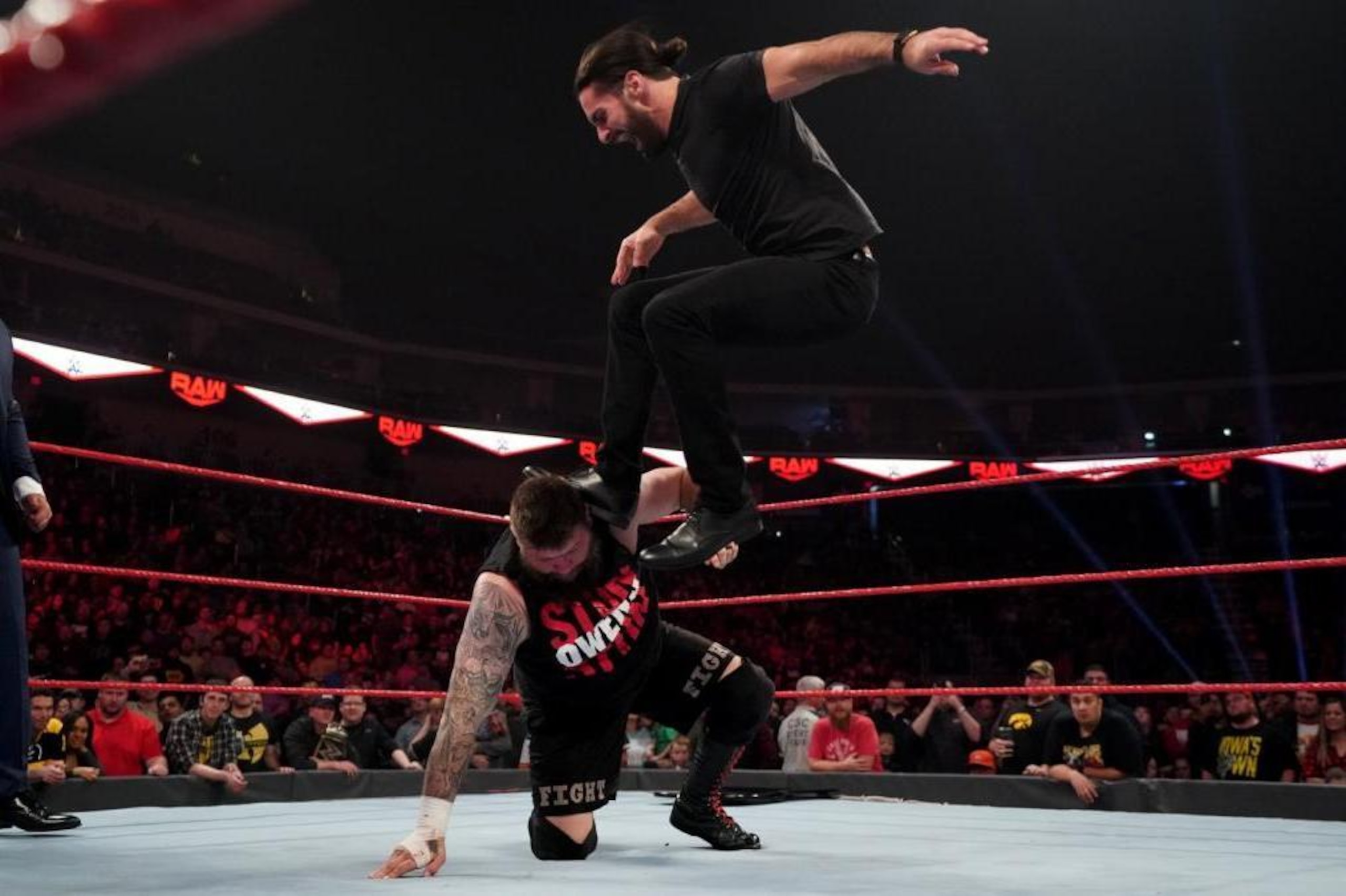 Seth Rollins delivering a Stomp to Kevin Owens.