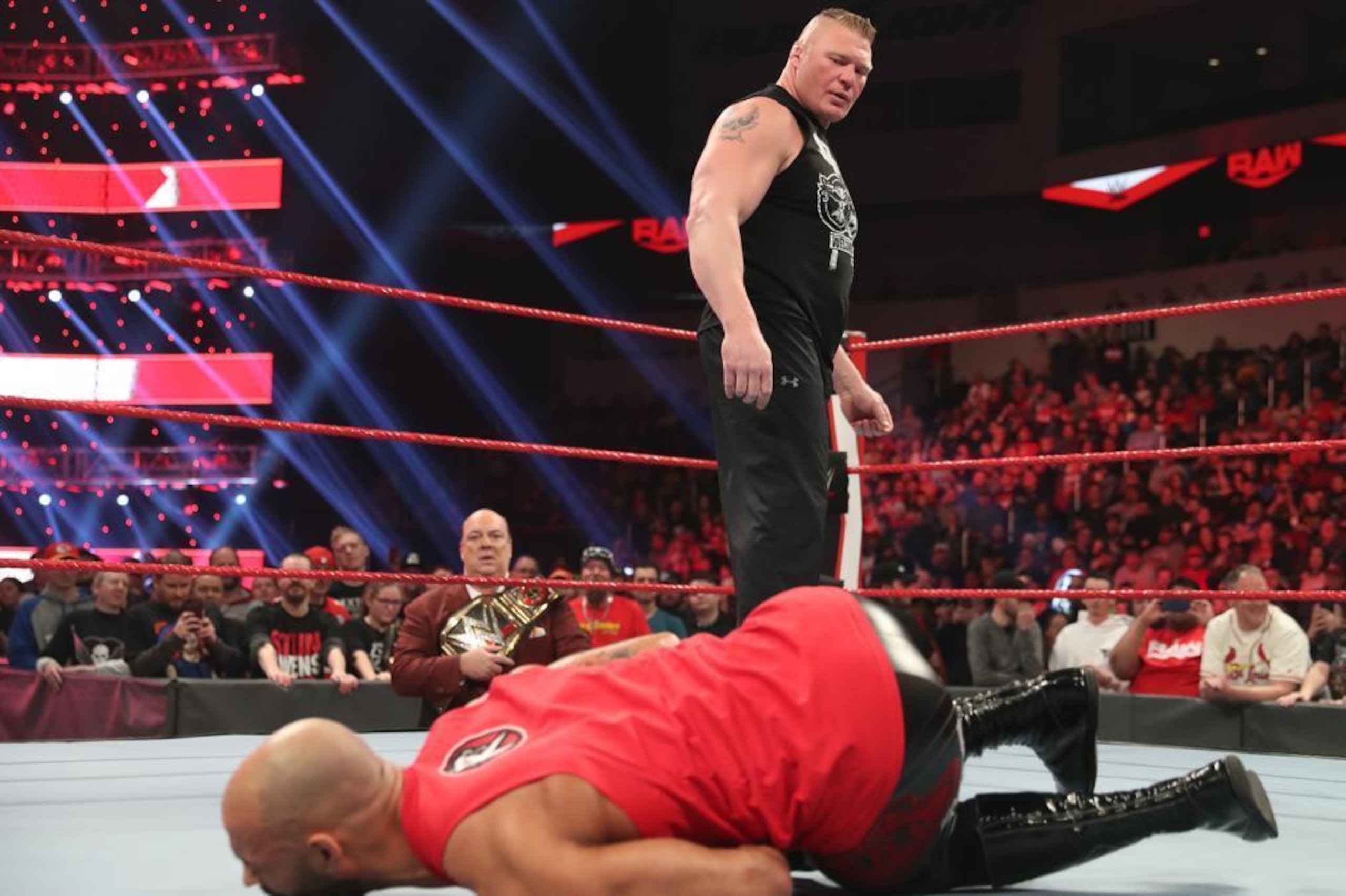 Brock Lesnar standing over Ricochet.