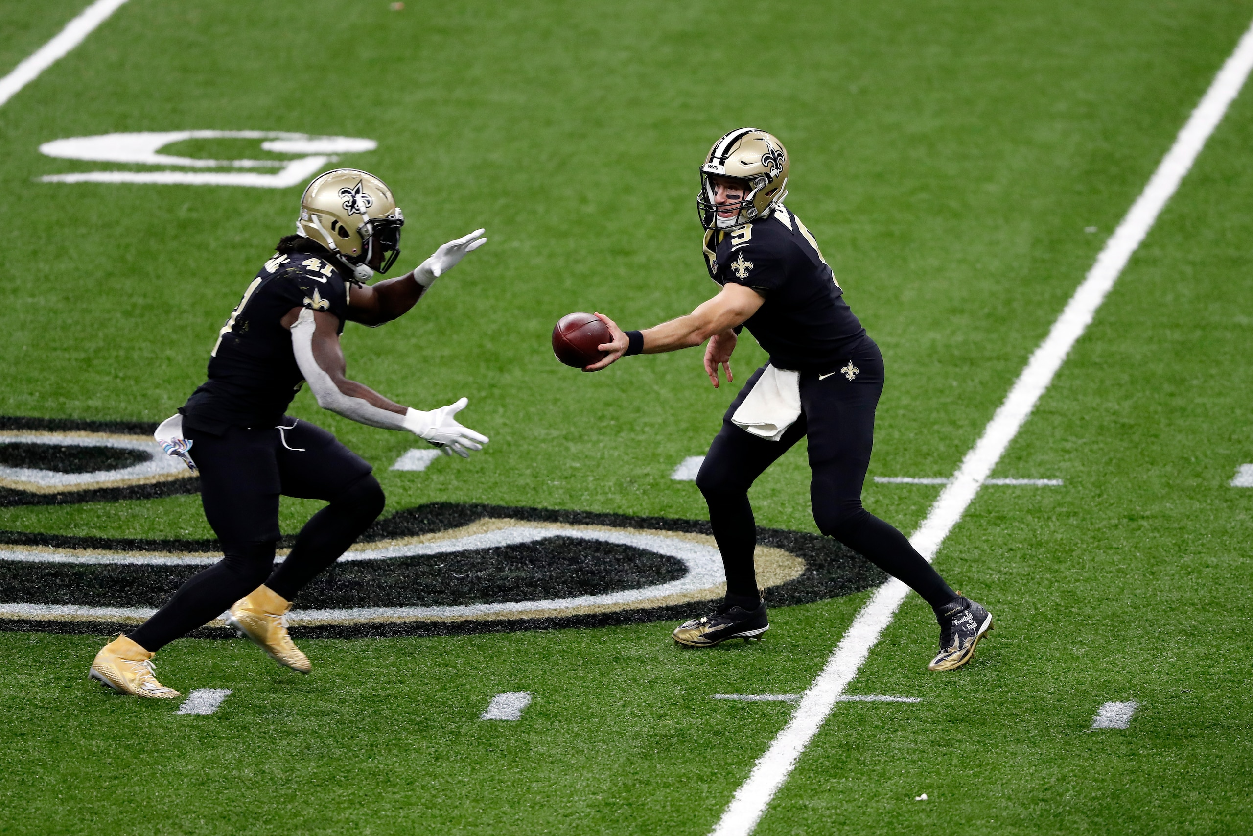 New Orleans Saints quarterback Drew Brees handing off to running back Alvin Kamara