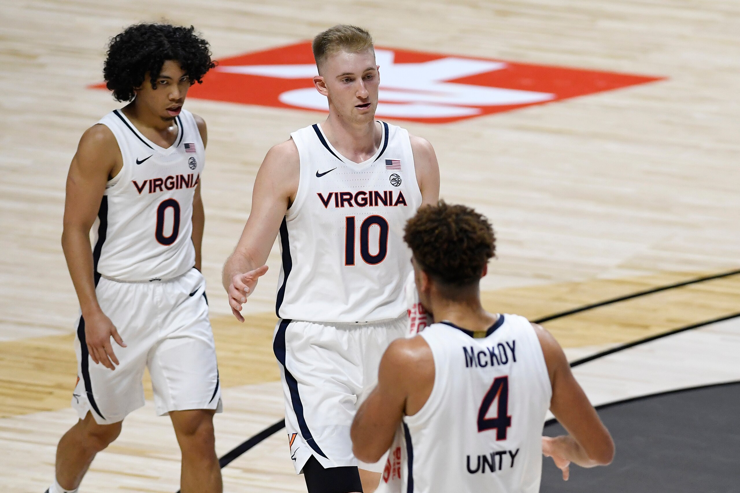 Virginia's Kihei Clark (0), Sam Hauser (10) and Justin McKoy (4)