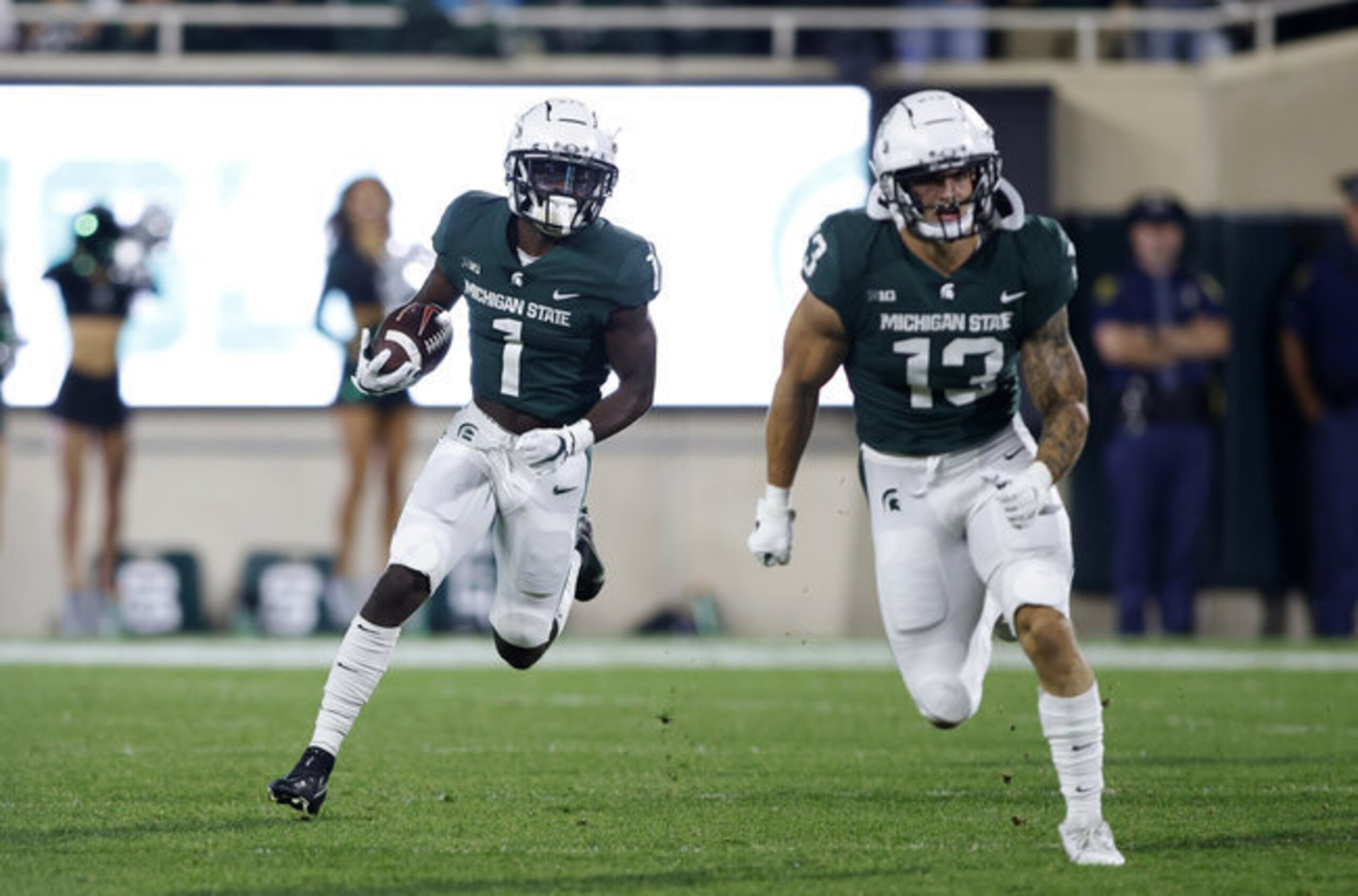 Michigan State's Jayden Reed (1) and Ben VanSumeren (13)