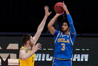 UCLA's Johnny Juzang and Michigan's Hunter Dickinson